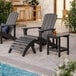 A group of black Lancaster Table & Seating modern Adirondack chairs next to a pool.
