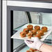 A person holding a plate of Abe's Vegan Chocolate Chip Mini Muffins.