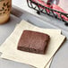 An individually wrapped Homefree vegan gluten-free chocolate chip brownie on a white surface.