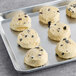 Preformed David's Cookies with blueberries and white dough on a baking sheet.