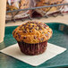 An individually wrapped David's Cookies chocolate chip muffin on a napkin.