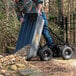 A man pushing a True Temper poly wagon full of rocks.