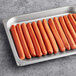 A white tray filled with Sabrett Skinless Beef Hot Dogs.