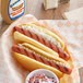 A Sabrett beef hot dog with onions and a bowl of coleslaw.