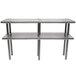 A stainless steel Advance Tabco double deck overshelf with metal legs holding two shelves.