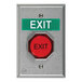 A red pneumatic universal button with black text next to a green sign on a silver wall.