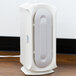 A white rectangular Hamilton Beach air purifier on a wood surface.