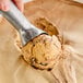 A hand using a metal scoop to scoop Klein's Vegan Coffee Royal Ice Cream