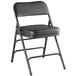 A Lancaster Table & Seating black vinyl folding chair with a black cushioned seat.