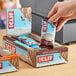 A hand holding a package of Clif Bar chocolate brownie energy bars.