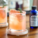 Two glasses of orange drinks with All The Bitter Aromatic Bitters and a slice of orange.