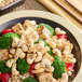A bowl of food with rice, broccoli, and cashews.
