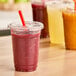 A table with plastic cups of red Earth Berry beverages.