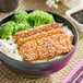 A bowl of rice with broccoli and meat.