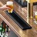 A black matte stainless steel surface-mount beer drip tray measuring 24 by 5 inches on a bar counter.