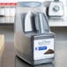 A plastic container of McCormick Culinary Whole Black Pepper on a counter.