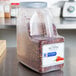 A case of three large McCormick Culinary crushed red pepper containers on a counter.