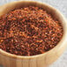 A bowl of red and orange McCormick Mesquite seasoning on a table.