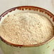 A bowl of McCormick Culinary Roasted Garlic Bread Seasoning on a wooden table.