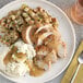 A plate of mashed potatoes, gravy, and chicken seasoned with McCormick Culinary Poultry Seasoning.