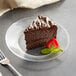 A piece of Ghirardelli chocolate cake with a strawberry on a plate.