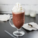 A glass cup filled with a chocolate frappe made with Ghirardelli Chocolate Frappe Mix.