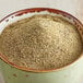 A bowl of McCormick Culinary Greek seasoning on a wooden table.