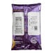 A close-up of a purple bag of Big Train Pumpkin Pie Chai Tea Latte Mix with white labels.