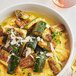 A bowl of zucchini and squash with McCormick Culinary Marjoram Leaves on a table.