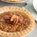A pecan pie topped with whole pecan pieces.