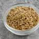 A bowl of McCormick Culinary Fennel Seeds on a gray surface.