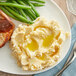 A plate of mashed potatoes and green beans with meat and brown sauce on top.