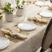 A table set with Posh Setting white plastic plates with gold place settings.