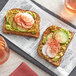 A slice of bread with paprika and vegetables on top.