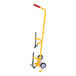 A yellow Vestil hand truck with black wheels and a red handle used to carry a fire extinguisher.