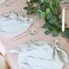 A table set with white plates and silverware on Posh Setting marble charger plates.