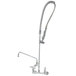 A T&S chrome wall mounted pre-rinse faucet with a hose.