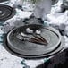 A table set with Posh Setting clear plastic charger plates with silver wide rims and silverware.