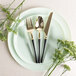 A plate with a Posh Setting gold and black plastic knife on it.