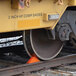 The wheel of a train with a Vestil polyurethane magnetic rail car wheel chock on tracks.