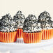 A cupcake with black sprinkles on top.
