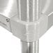A stainless steel Advance Tabco mixer table shelf with a utensil rack pole.