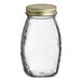 A Classic Queenline clear glass honey jar with a gold metal lid.