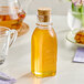 A 5.5 oz. glass Muth honey jar with a cork on a table.