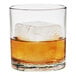 A Tossware plastic rocks glass with a drink and ice cubes in it.