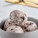 A bowl of Meadowvale hard ice cream with white and brown scoops.