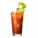A Tossware stackable highball glass filled with orange liquid and ice with a lime garnish.