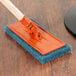 A 3M Doodlebug blue scrub pad on a wood surface.