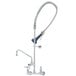 A T&S chrome wall mounted pre-rinse faucet with a hose and sprayer.
