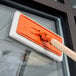 A white cleaning pad with a handle on a window.